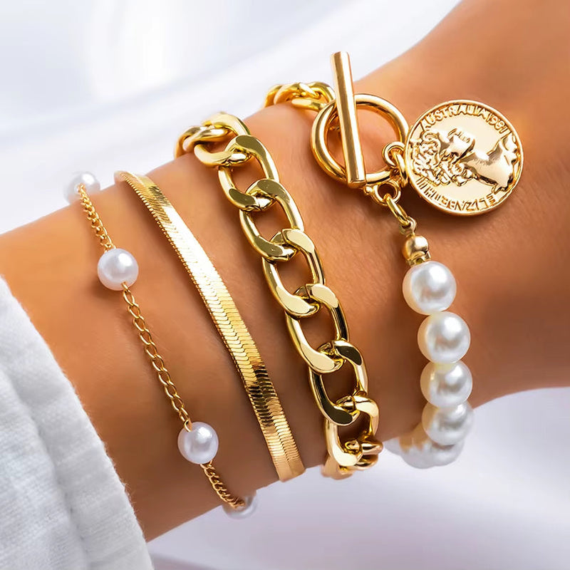 Gold imitation pearl chain bracelet with matching gold bracelets set on wrist