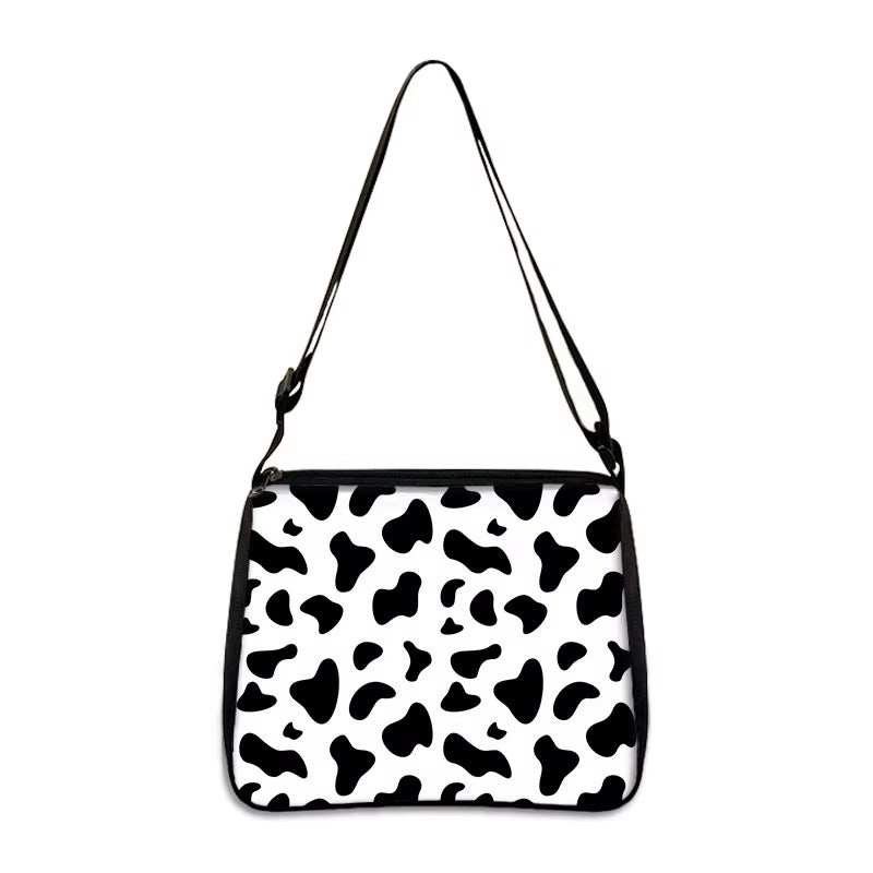 Cow print small shoulder bag with adjustable strap and black and white pattern