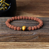 Royal Green Tiger Eye Vajra Rudraksha beaded meditation bracelet with natural tiger eye stone centerpiece on wooden surface