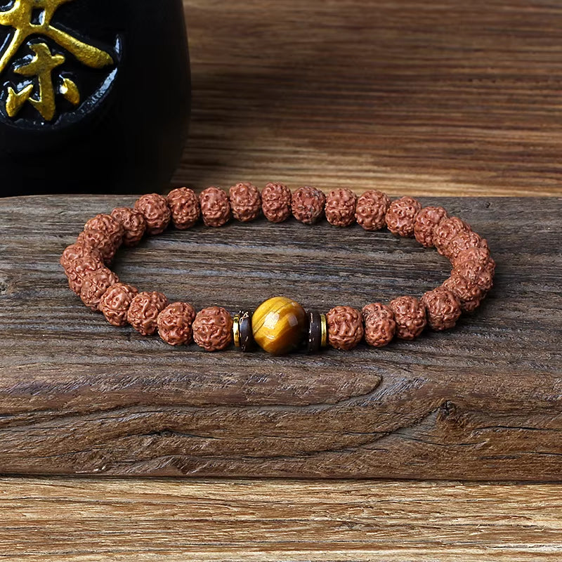 Royal Green Tiger Eye Vajra Rudraksha beaded meditation bracelet with natural tiger eye stone centerpiece on wooden surface