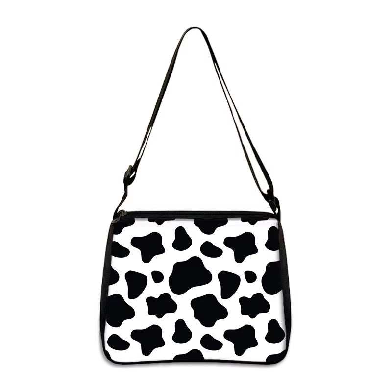 Cow print small shoulder bag with black and white pattern and adjustable strap