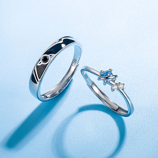 Dream Planet Couple Rings set with sterling silver and gemstone details on a blue background