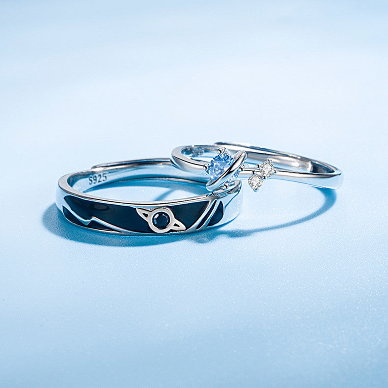 Dream Planet Couple Rings set in 925 sterling silver with geometric design and gemstone accents on light blue background