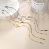 Silver and gold knot pendant anklets in stainless steel with chain link design on a white surface