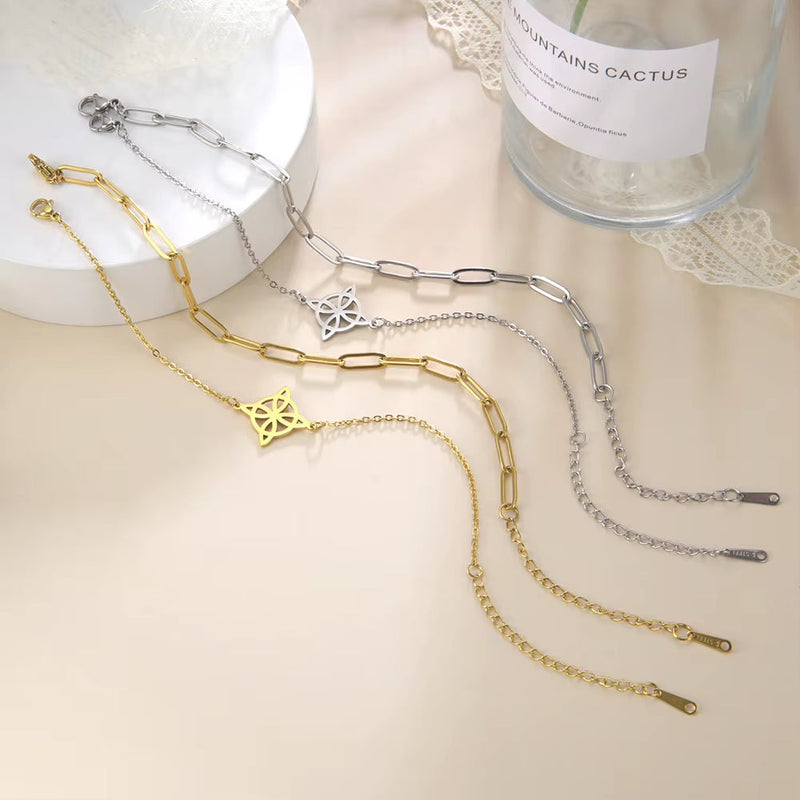 Silver and gold knot pendant anklets in stainless steel with chain link design on a white surface