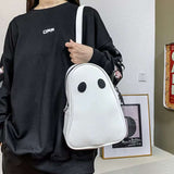 White Halloween cartoon ghost shaped handbag with black eyes worn by a person in a black sweatshirt