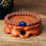 Royal Green Tiger Eye Vajra Rudraksha meditation beaded bracelet on wooden stand