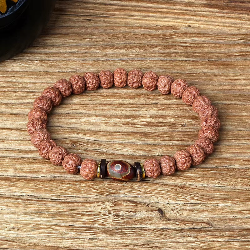 Natural Rudraksha beaded bracelet with Royal Green Tiger Eye Vajra centerpiece on wooden background