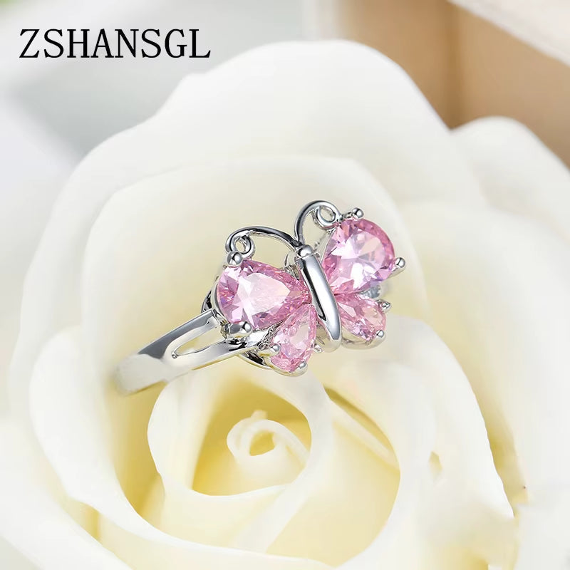 Sterling silver butterfly ring with pink gemstone wings on white rose background