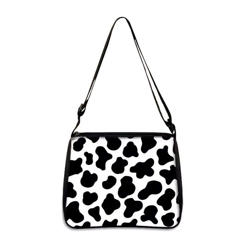 Cow print small shoulder bag with adjustable strap and black and white pattern