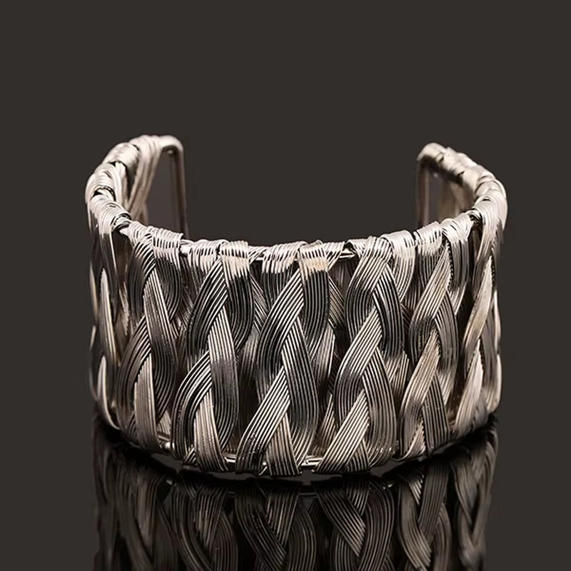 Silver woven punk style cuff bangle bracelet with intricate braided design on black background