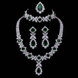 Cubic Zirconia Tassel Drop green and white stone necklace, earrings, ring, and bracelet set on black background