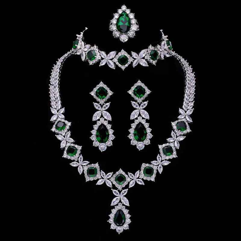 Cubic Zirconia Tassel Drop green and white stone necklace, earrings, ring, and bracelet set on black background