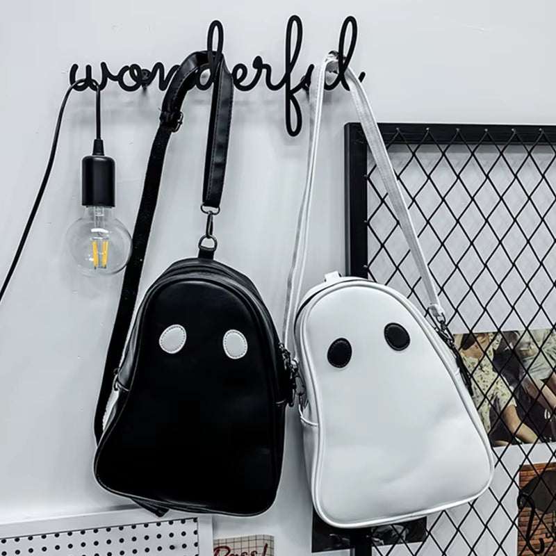 Halloween cartoon ghost themed black and white backpacks hanging on wall hooks with modern decor background