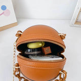Brown basketball-shaped ball purse for teenagers with gold chain zipper open showing cosmetic items inside