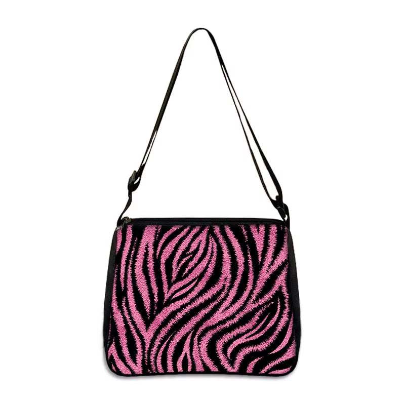 Small shoulder bag with pink and black zebra print design and adjustable strap
