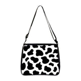 Cow print small shoulder bag with adjustable strap and black accents