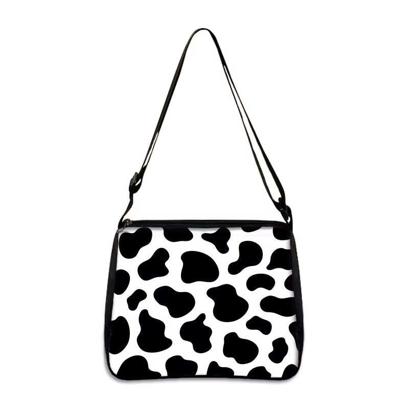 Cow print small shoulder bag with adjustable strap and black accents