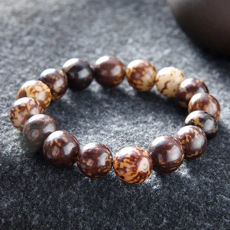 Nature Bodhi 18 Style Beads Bracelet made of natural Rudraksha beads with earthy brown tones on a dark fabric background