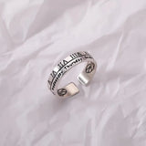 Silver fidget spinner ring with calendar and Roman numerals design on crumpled white background