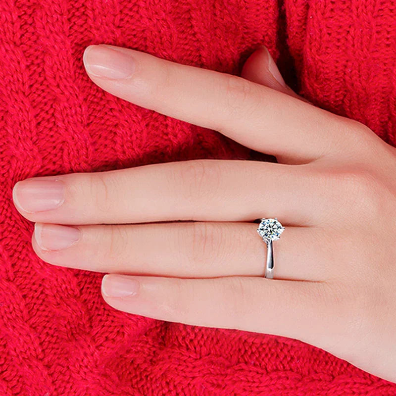 925 sterling silver romantic wedding ring with cubic zirconia on hand against red sweater background