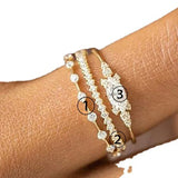 close-up of three delicate 14K gold stackable rings with cubic zirconia stones on finger