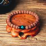 Royal Green Tiger Eye Vajra beaded Rudraksha bracelet on wooden stand