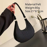 Black felt ball purse for teenagers with textured design and shoulder strap, lightweight and compact size.